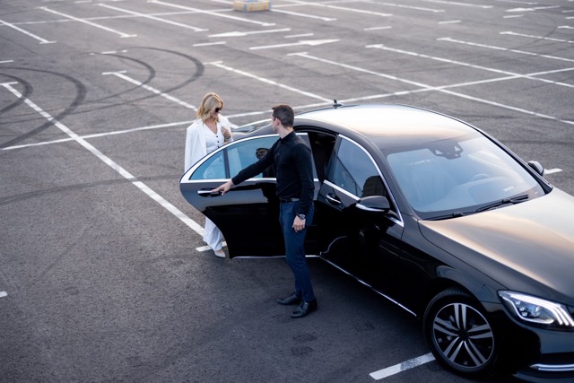 Guest being welcomed into a private chauffeur car for seamless ground transportation