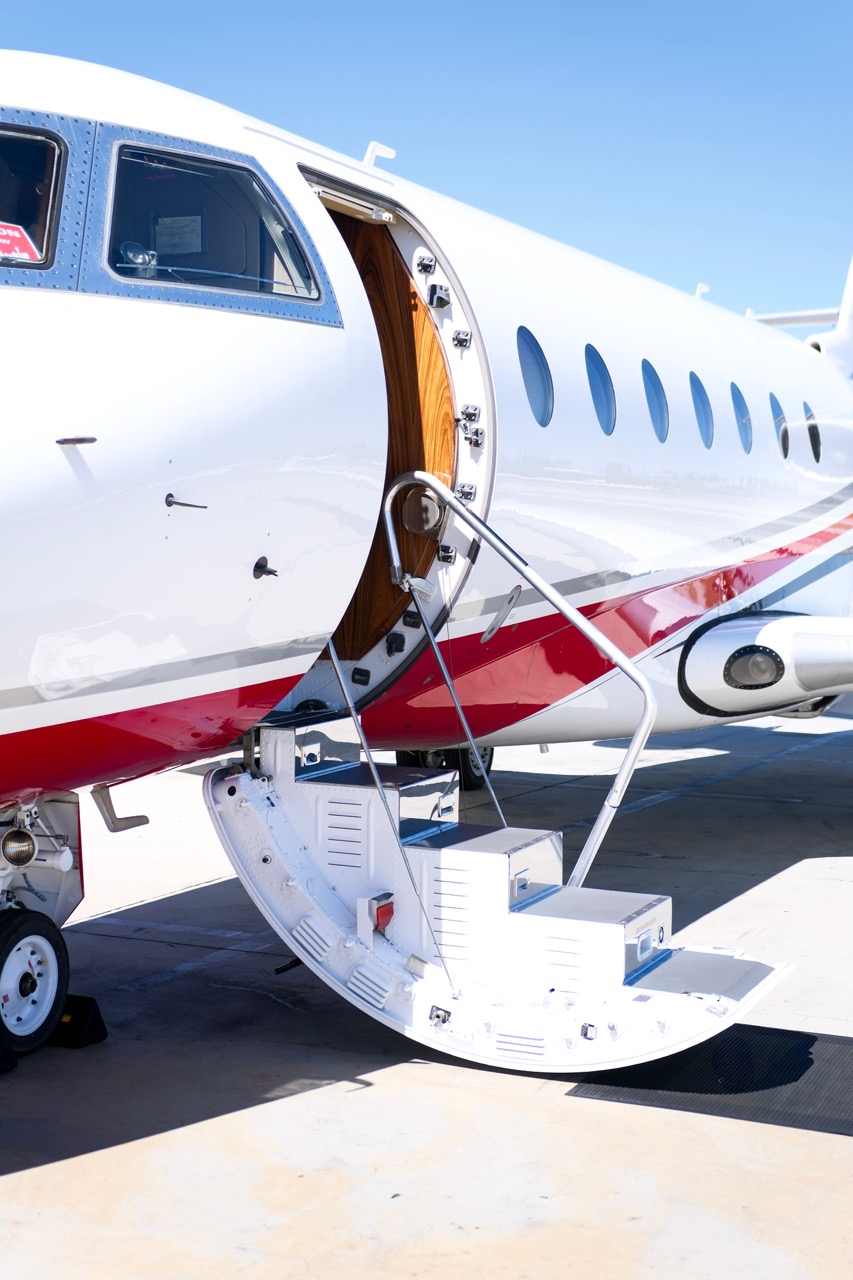 Challenger 300 private jet on tarmac with stairs extended and Amalfi Jets mat at the cabin entrance.