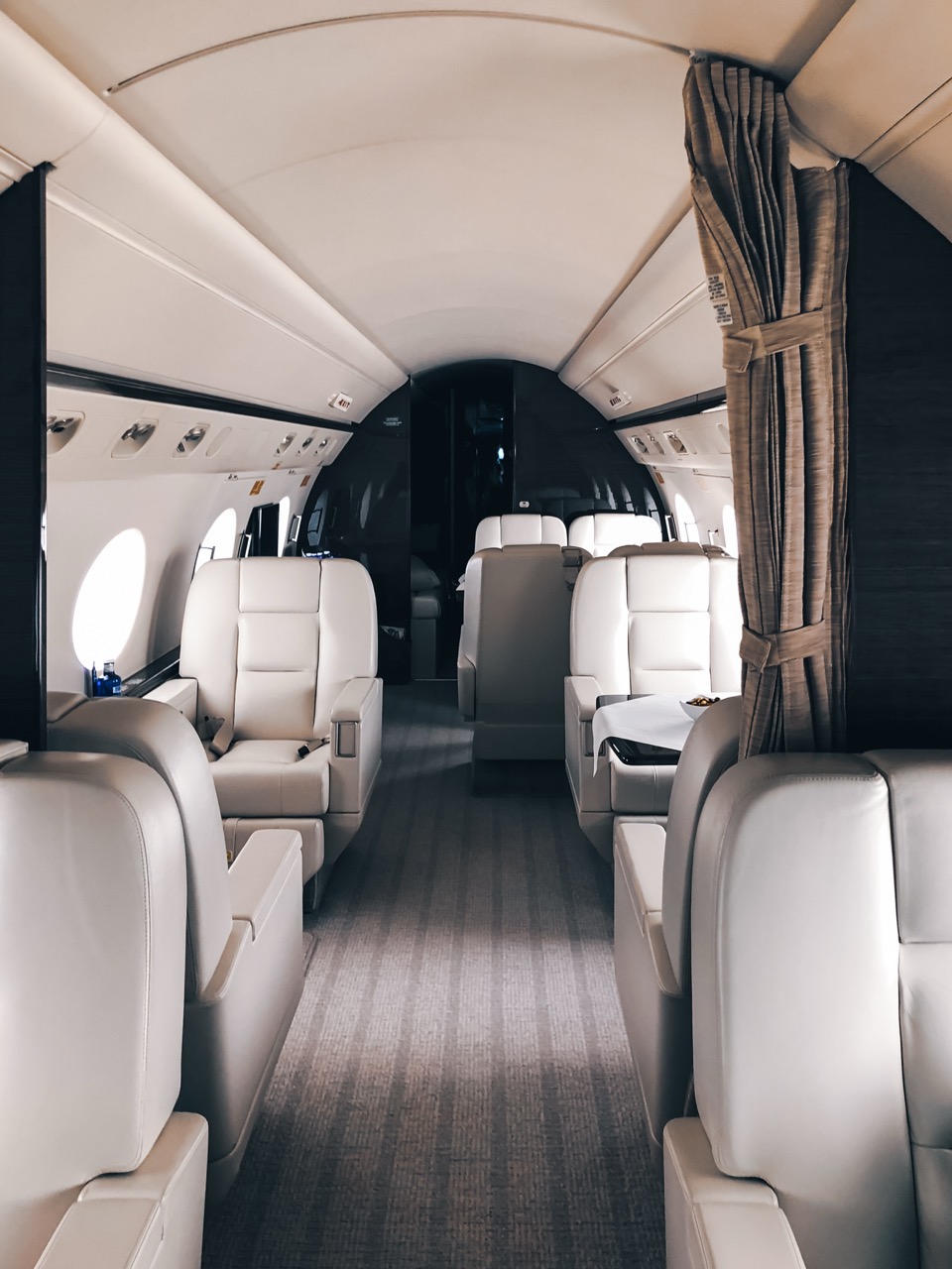 Gulfstream G650 cabin with cream leather seats, oval windows, and spacious layout designed for long-range travel.