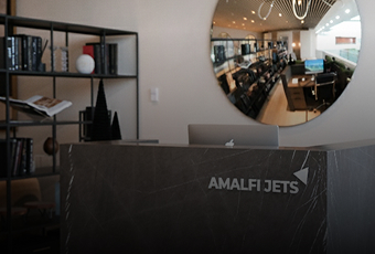Pilot adjusting controls inside a modern private jet cockpit with illuminated flight instruments and navigation screens.