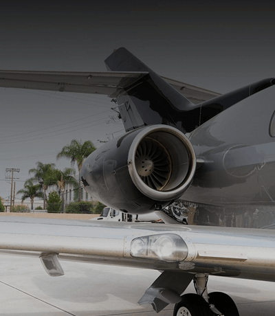 Amalfi Jets Hawker 900 aircraft charter parked on tarmac, featuring rear engine and polished silver fuselage.