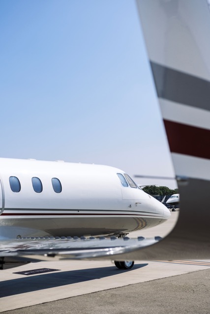 Private jet positioned on the tarmac, elegantly framed by its own tail section