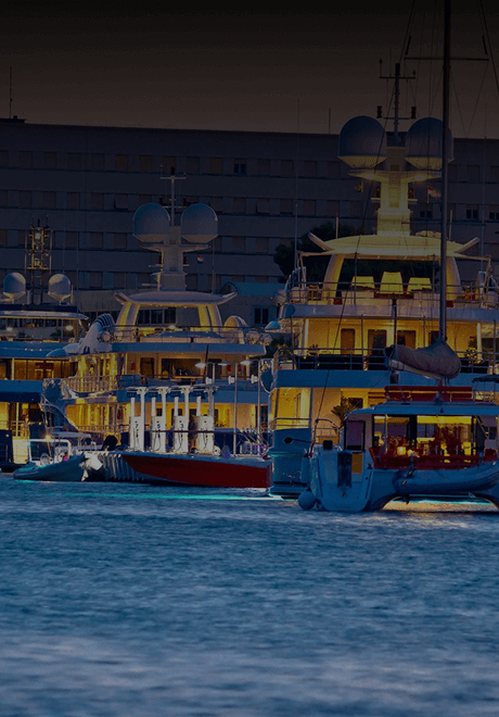 Elegantly lit up Private yacht charters on the water at a marina during sunset