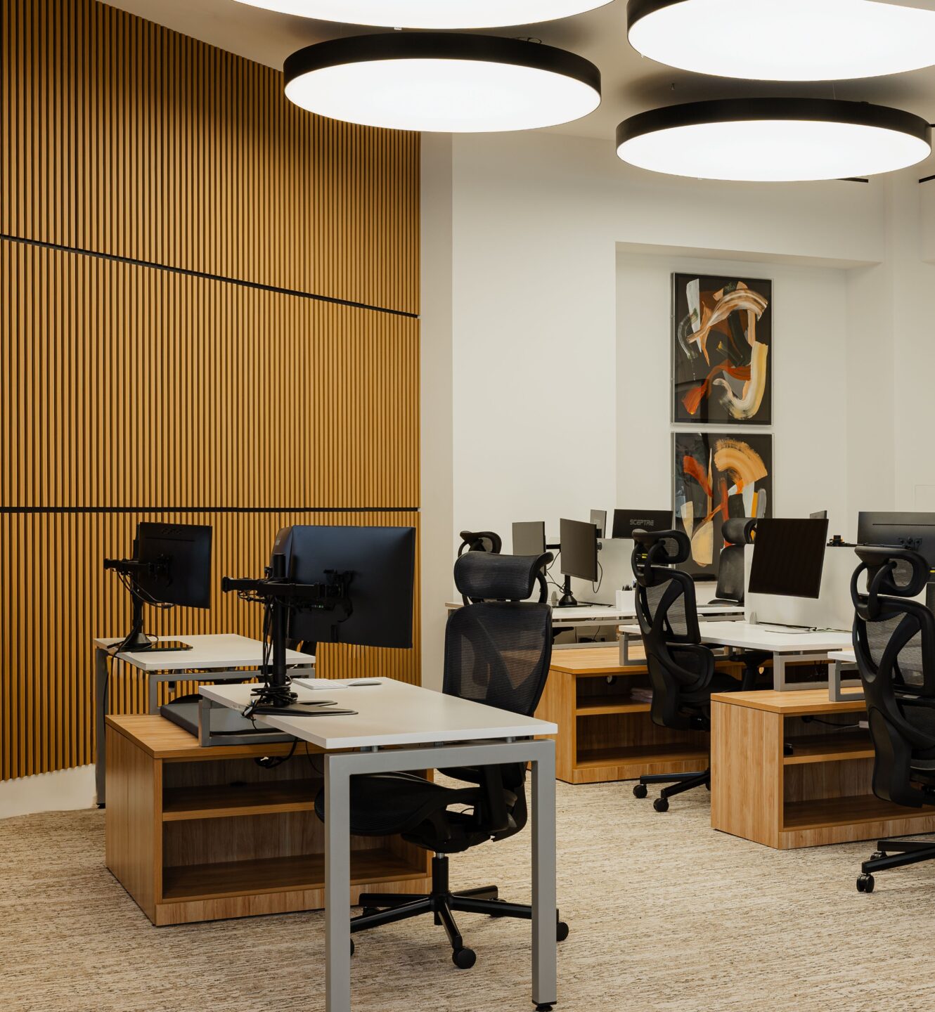 Amalfi Jets operations office with rows of desks, monitors and round ceiling lights.